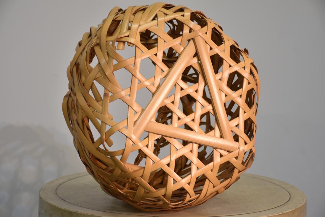 A beautifully handcrafted Japanese Ikebana bamboo vase featuring a striking bold weave design in natural light-toned bamboo