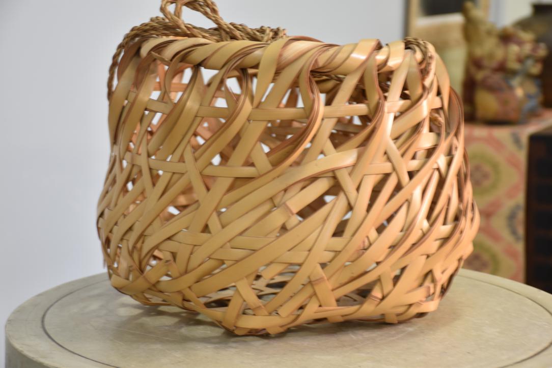 A beautifully handcrafted Japanese Ikebana bamboo vase featuring a striking bold weave design in natural light-toned bamboo