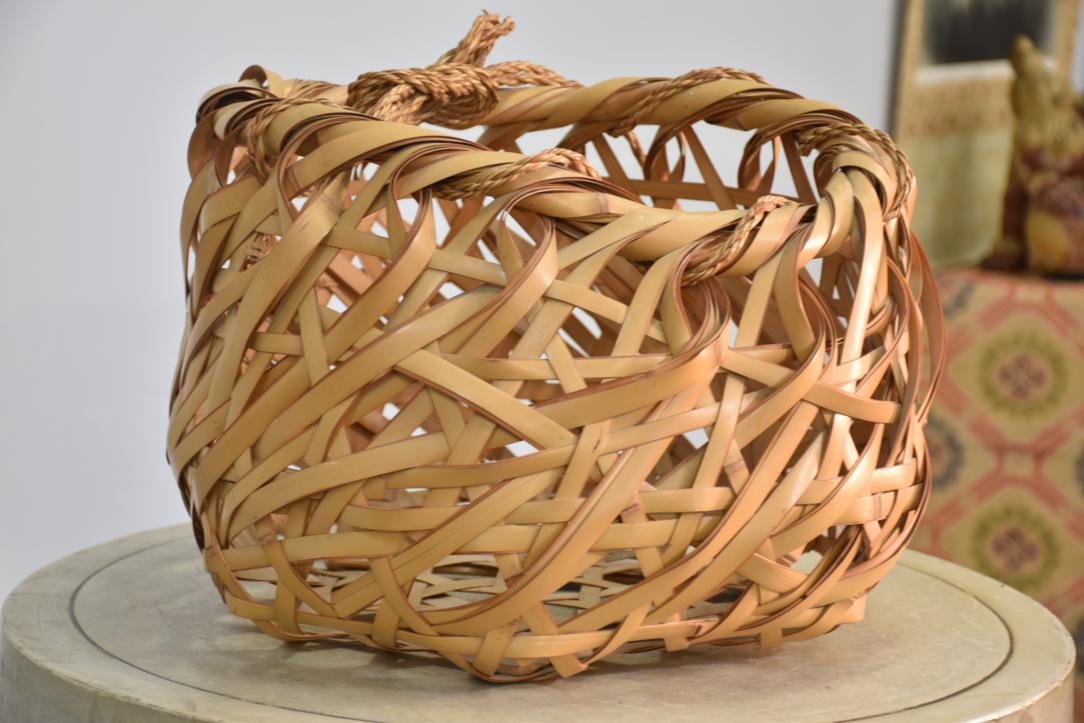 A beautifully handcrafted Japanese Ikebana bamboo vase featuring a striking bold weave design in natural light-toned bamboo