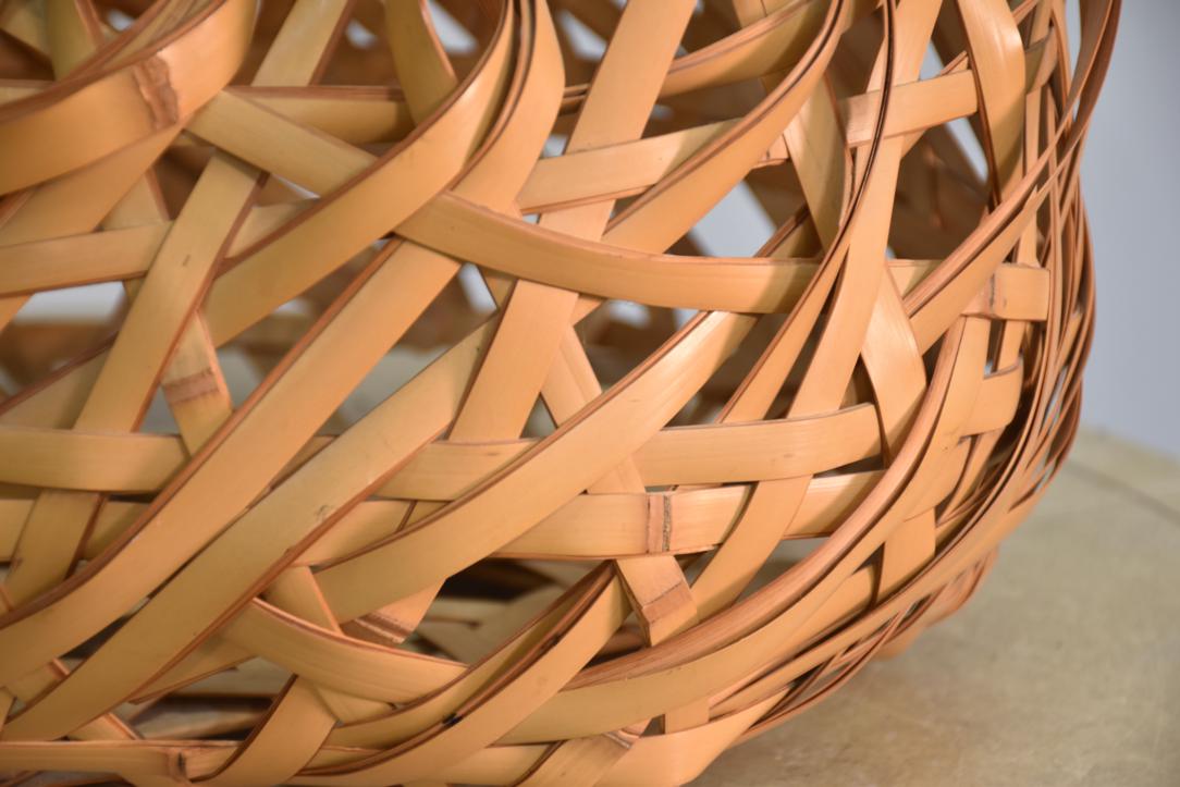 A beautifully handcrafted Japanese Ikebana bamboo vase featuring a striking bold weave design in natural light-toned bamboo